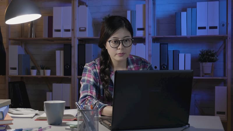 Eine Ghostwriterin sitzt am Laptop und schreibt die Bewerbung für jemand anderes